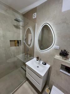 a bathroom with a white sink and a mirror at Refresh apartman in Belgrade +19 photos