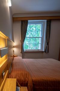 a bedroom with a bed and a window at The Nayland Hotel in London +21 photos