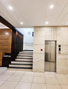 eine Lobby mit Treppe und einem Metallaufzug in der Unterkunft Red Queen in Raigarh