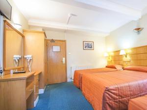 a hotel room with two beds and a sink at The Nayland Hotel in London
