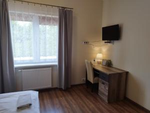 a bedroom with a desk and a bed and a window at Swojski Klimat in Płońsk