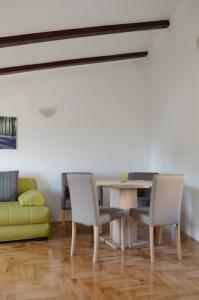 jadalnia ze stołem, krzesłami i kanapą w obiekcie Holiday Home Archipelago w mieście Lovran