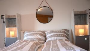 una camera da letto con un letto con uno specchio sul muro di Holiday Home Archipelago a Lovran (Laurana)
