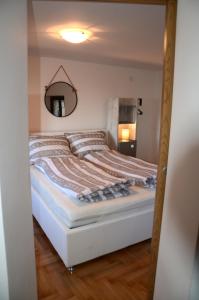 Schlafzimmer mit einem Bett und einem Spiegel an der Wand in der Unterkunft Holiday Home Archipelago in Lovran