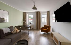 a living room with a couch and a table at Limehome Chemnitz Hartmannstraße in Chemnitz