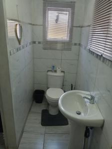 a white bathroom with a toilet and a sink at KaChichima in Springs +38 photos