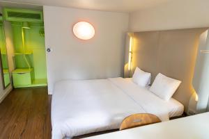 a bedroom with a large white bed with white pillows at Campanile Grenoble Nord - Saint-Egrève in Saint-Égrève +18 photos