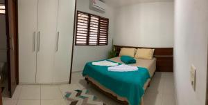 a bedroom with a bed with towels on it at Pousada e Hostel Praia do poço in Cabedelo