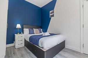 a blue bedroom with a bed and a blue wall at Coventry Contractor Hub - 4-Bedroom House with Free Parking-CV5 in Spon End