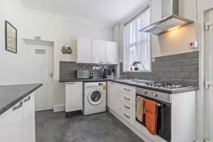 a kitchen with a stove and a washer and dryer at Coventry Contractor Hub - 4-Bedroom House with Free Parking-CV5 in Spon End