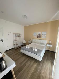 ein Schlafzimmer mit einem großen Bett und Holzböden in der Unterkunft Tra te e il Mare in Porto Torres