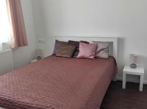 a bedroom with a large bed with pink pillows at Parkside Home in Törökbálint