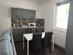 a kitchen with a table and chairs and a microwave at Parkside Home in Törökbálint