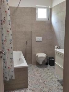 a bathroom with a toilet and a tub and a sink at Parkside Home in Törökbálint +5 photos