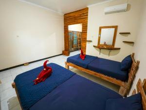 a bedroom with two beds and a red squid decoration at Sunrise Lodge and Lounge Hotel in Panji