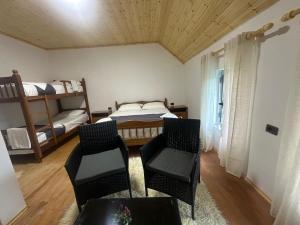 a room with two bunk beds and two chairs at Bujtina Tata in Curraj