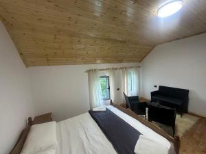 a bedroom with a bed and a desk and a piano at Bujtina Tata in Curraj