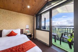 a bedroom with a bed and a large window at The Ayura Palace l Family Events I Multi Cuisine Restaurant l Sky Bonfire l Lift l Power Backup l Free Parking l Kufri By Exotic Stays in Kūfrī