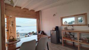 a kitchen with a table and a large window at Refugio en Tril tril in Bahía Mansa