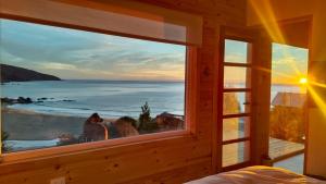 a window in a room with a view of the ocean at Refugio en Tril tril in Bahía Mansa +11 photos