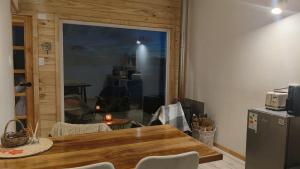 a dining room with a table and a large window at Refugio en Tril tril in Bahía Mansa