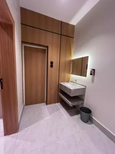 a bathroom with a sink and a wooden door at البساتين بارك للشقق المخدومه in Al Baha