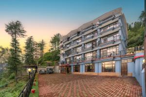 a large building with a driveway in front of it at The Ayura Palace l Family Events I Multi Cuisine Restaurant l Sky Bonfire l Lift l Power Backup l Free Parking l Kufri By Exotic Stays in Kūfrī