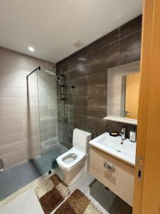 a bathroom with a toilet and a shower and a sink at Appartement a meknes in Meknès