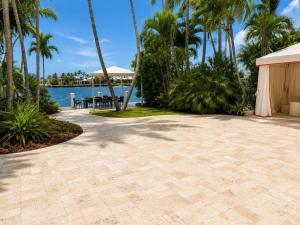 a patio with palm trees and a body of water at Monaco Bay Hotel in Fort Lauderdale +3 photos
