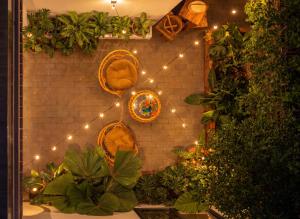 a brick wall with a string of lights and plants at An Hiên Home in Danang