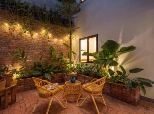 a patio with chairs and a table and plants at An Hiên Home in Danang +26 photos