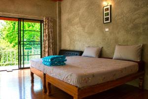 a bedroom with a bed in a room with a window at Maewin Resort in Ban Huai Rin