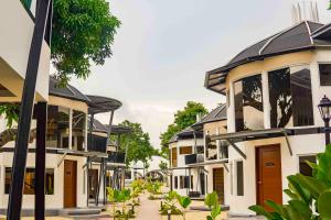 eine Häuserreihe in einer Straße mit Bäumen in der Unterkunft Fizz Diving Resort in Panglao