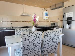 a kitchen with a counter with two chairs in it at Lucipri CyN in Arroyito
