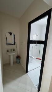 a bathroom with a toilet and a sink and a mirror at Résidence Talhaoui in Saïdia +8 photos