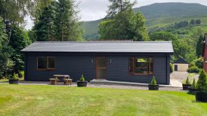 a blue shed with a picnic table in a yard at Bunroy Park in Fort William