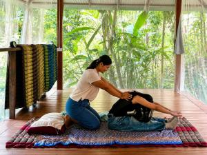 a woman sitting on the floor with a girl on a rug at Maewin Resort in Ban Huai Rin