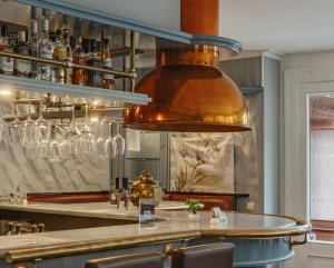 a large copper light hanging over a bar at G&H Hotel Rosengarten in Rosengarten