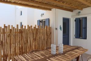 a wooden fence with a wooden table and chairs at Almira Prassa Beach House Kimolos in Prasonísi