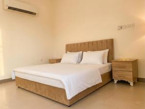 a bedroom with a large bed and a night stand at Aknan Center Market in Salalah