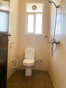 a bathroom with a toilet and a window and a shower at Aknan Center Market in Salalah +14 photos