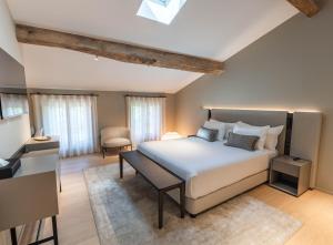 a bedroom with a large white bed and a chair at La Villa des Vignes in Saint-Émilion +121 photos