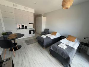 a bedroom with two beds and a table and a kitchen at Convenient Studio for 2 in Nokia