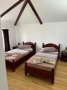two twin beds in a room with wooden floors at Casa Dyny 2 Mai in 2 Mai