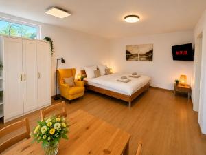a bedroom with a bed and a chair and a table at Alb-Welle I Design-Apartment mit privater Sauna & Badkap-Nähe in Albstadt