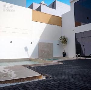 a white building with a potted tree in a courtyard at Eight House villa in Jeddah