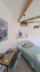 a bedroom with a bed and a desk and a table at Perla Di Macchia in Bonifacio