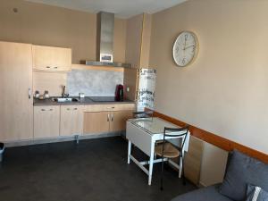 a kitchen with a table and a clock on the wall at Acogedor y tranquilo apartamento in Punta Umbría