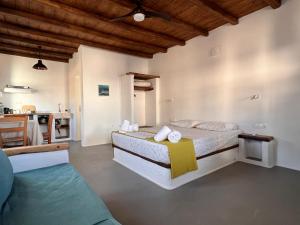 a bedroom with a large bed and a kitchen at KOLOMBA GUESTS House in Vrachonisída Skylonísi