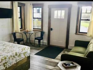 a room with a bed and a couch and a table at The Lupine | Cross Stone Cabins • Walk to Rangeley Lake in Rangeley